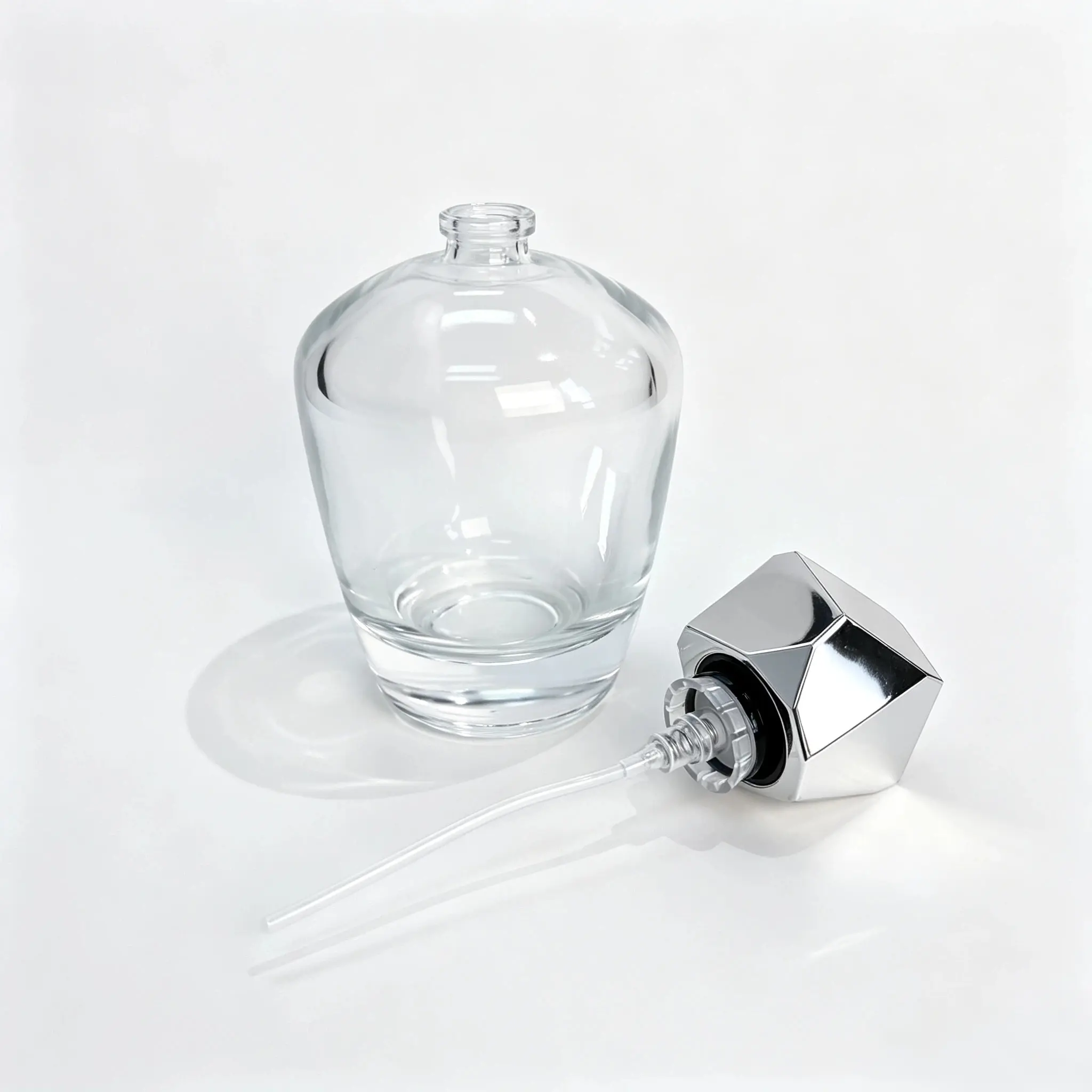 100ml Rounded Glass Perfume Bottle with Separate Faceted Cap 100ml rounded glass perfume bottle shown bare with the geometric faceted outer cap positioned separately beside the bottle