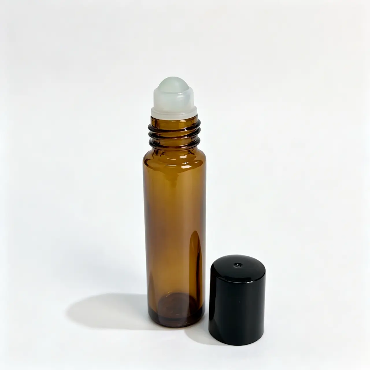 10ml Amber Glass Roller Bottle Roller and Cap Details 10ml amber glass roll on perfume bottle with roller ball assembly and cap separated for component evaluation