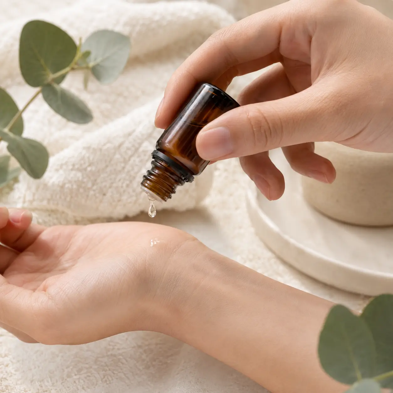15ml Euro Dropper Essential Oil Bottle Hand Application 15ml Euro dropper essential oil bottle dispensing a visible drop of oil onto a hand