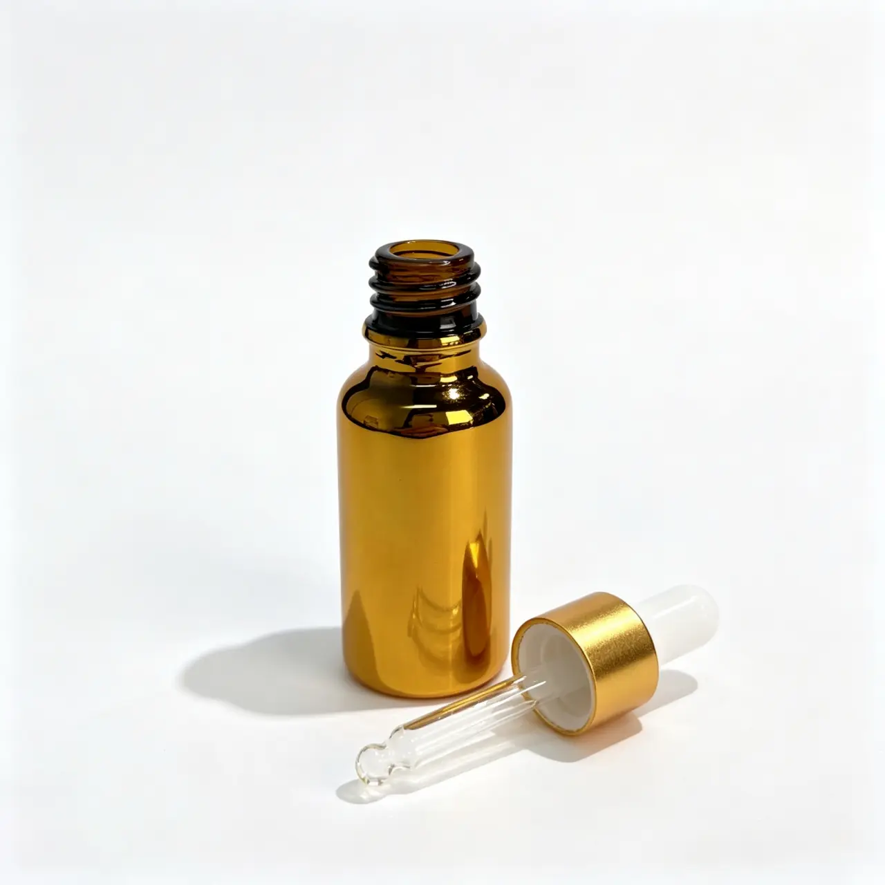 20ml gold Boston round bottle and matching dropper shown lying on their sides