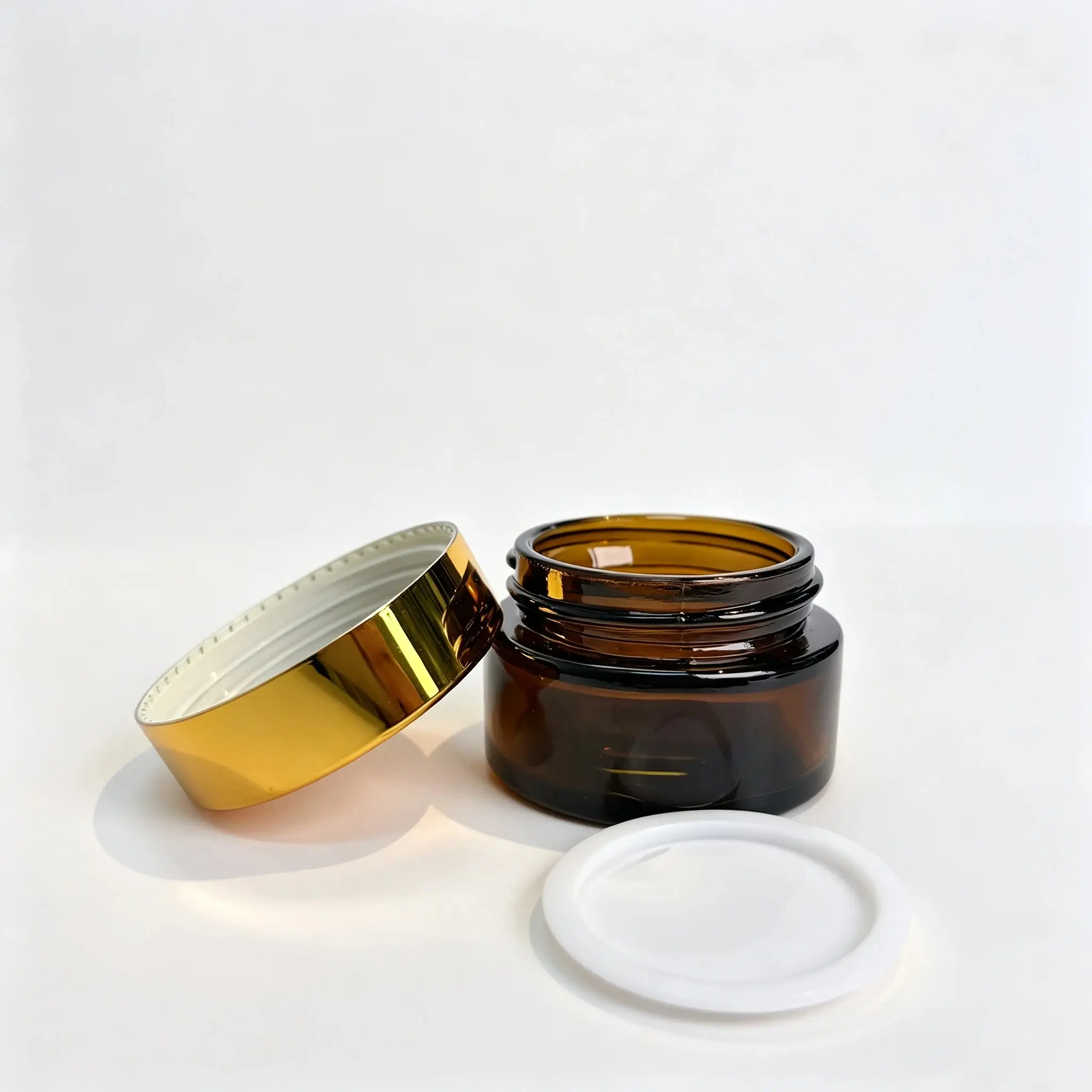 30g amber glass cosmetic cream jar displayed with its separate gold-colored lid for component review