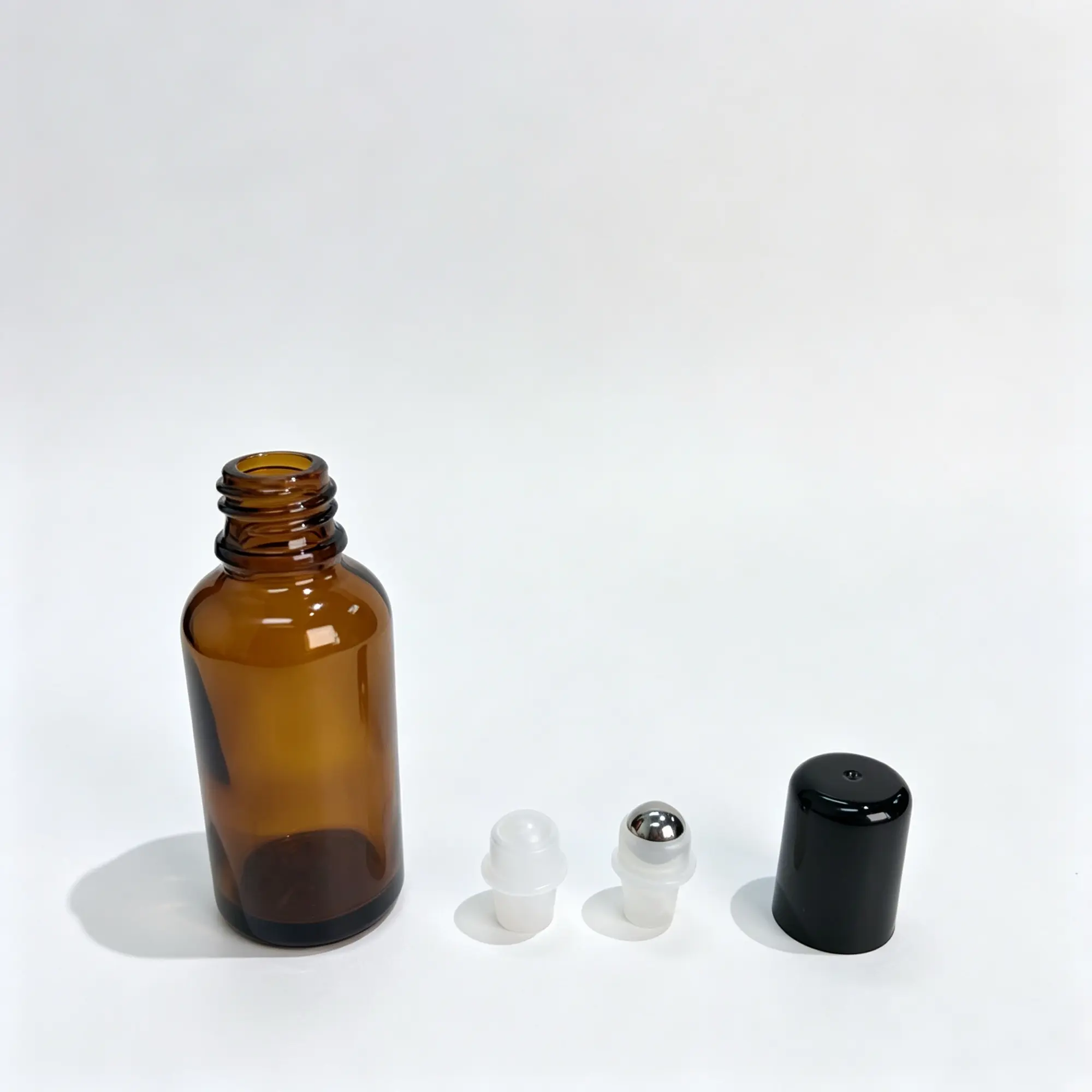 30ml Amber Glass Roller Bottle Roller Ball and Cap Options 30ml amber glass essential oil roller bottle shown with glass and stainless steel roller ball options and cap components