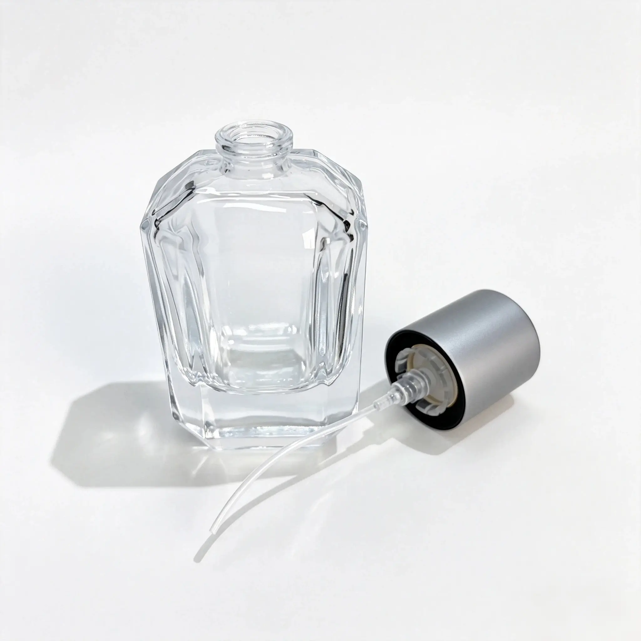30ml faceted glass perfume bottle shown bare with the outer cap and crimp sprayer displayed separately for component reference