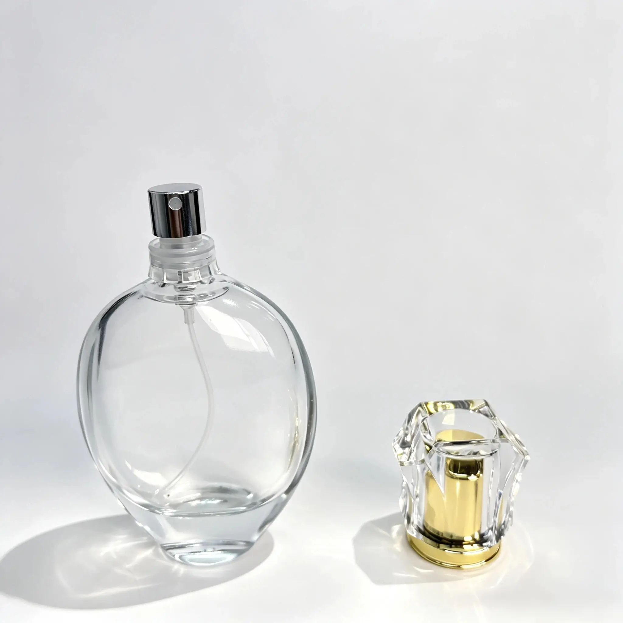 50ml Oval Glass Perfume Bottle with Separate Cap 50ml oval heavy base glass perfume bottle shown bare with its outer cap positioned separately beside the bottle