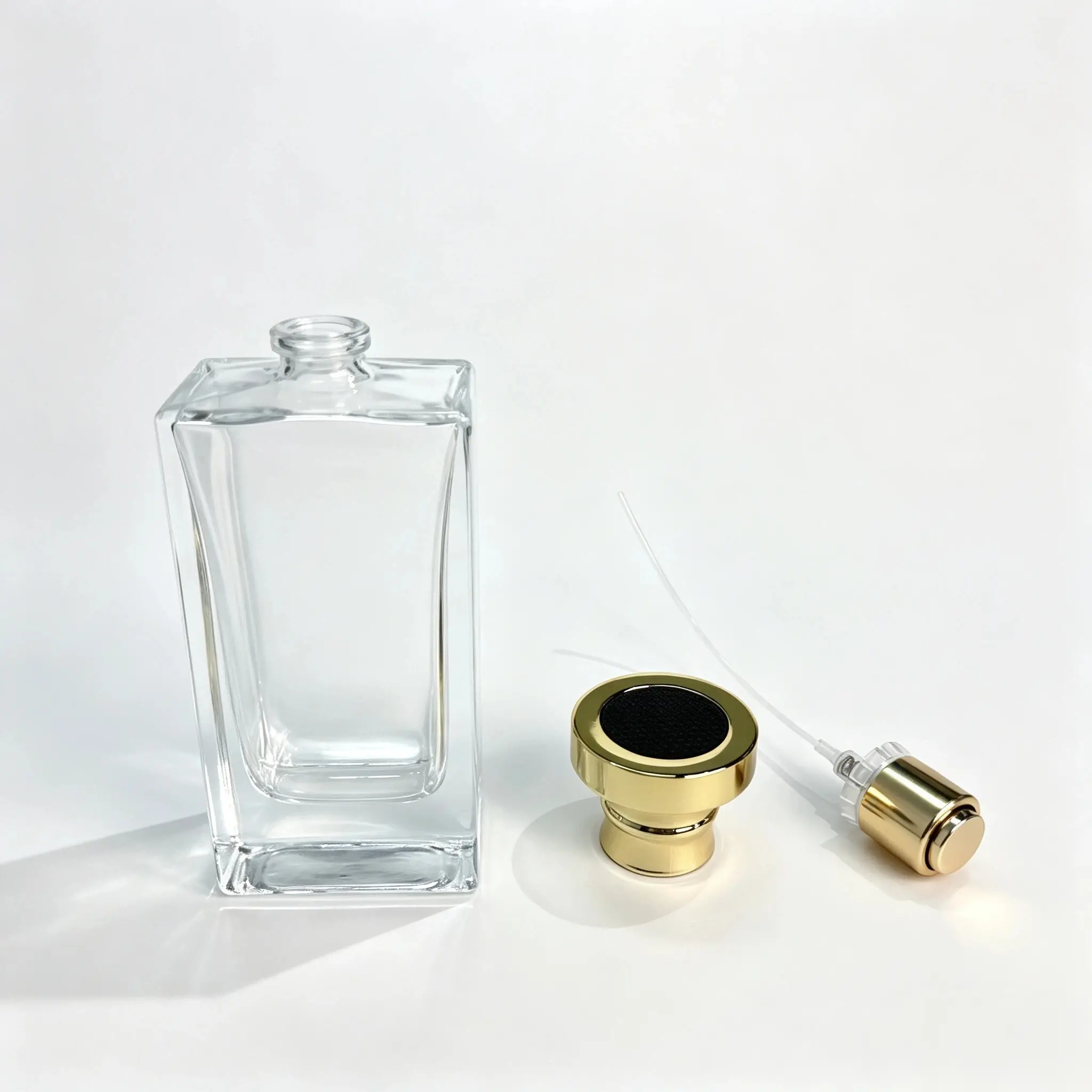 50ml rectangular perfume bottle shown bare with the gold crown style outer cap displayed separately beside the bottle