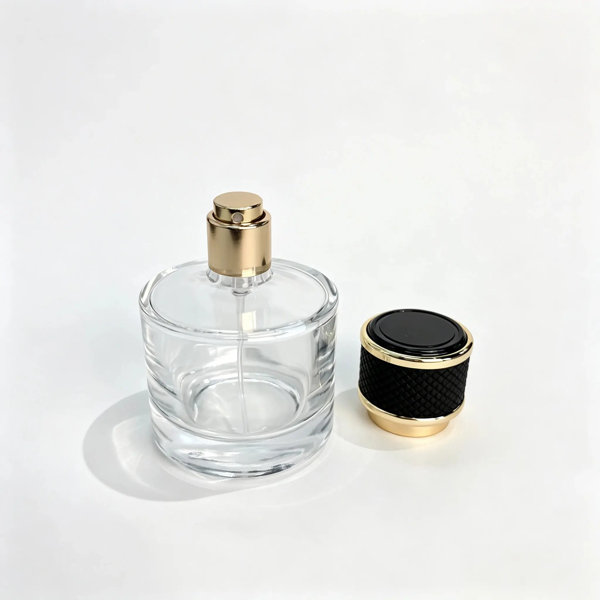 50ml Round Perfume Bottle with Upright Black Gold Cap 50ml round perfume bottle shown bare with the black gold leather grain cap standing separately beside the bottle