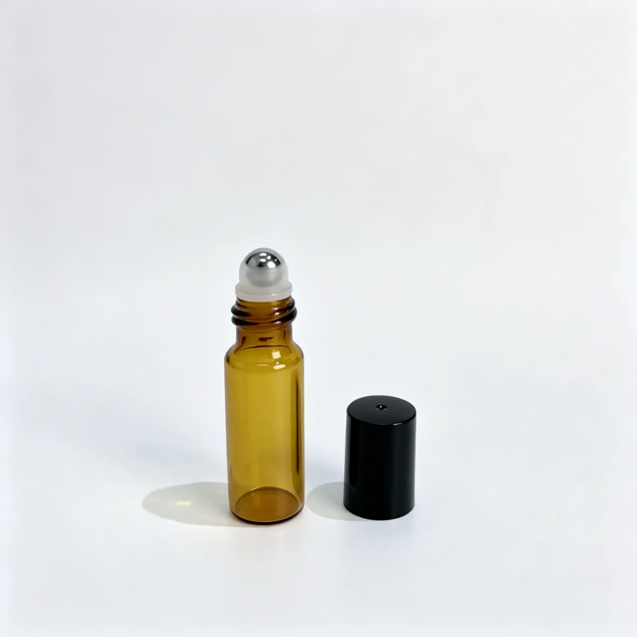 5ml Amber Roll On Bottle Components Detail 5ml amber roll on bottle shown separately with roller assembly and cap components for structural detail