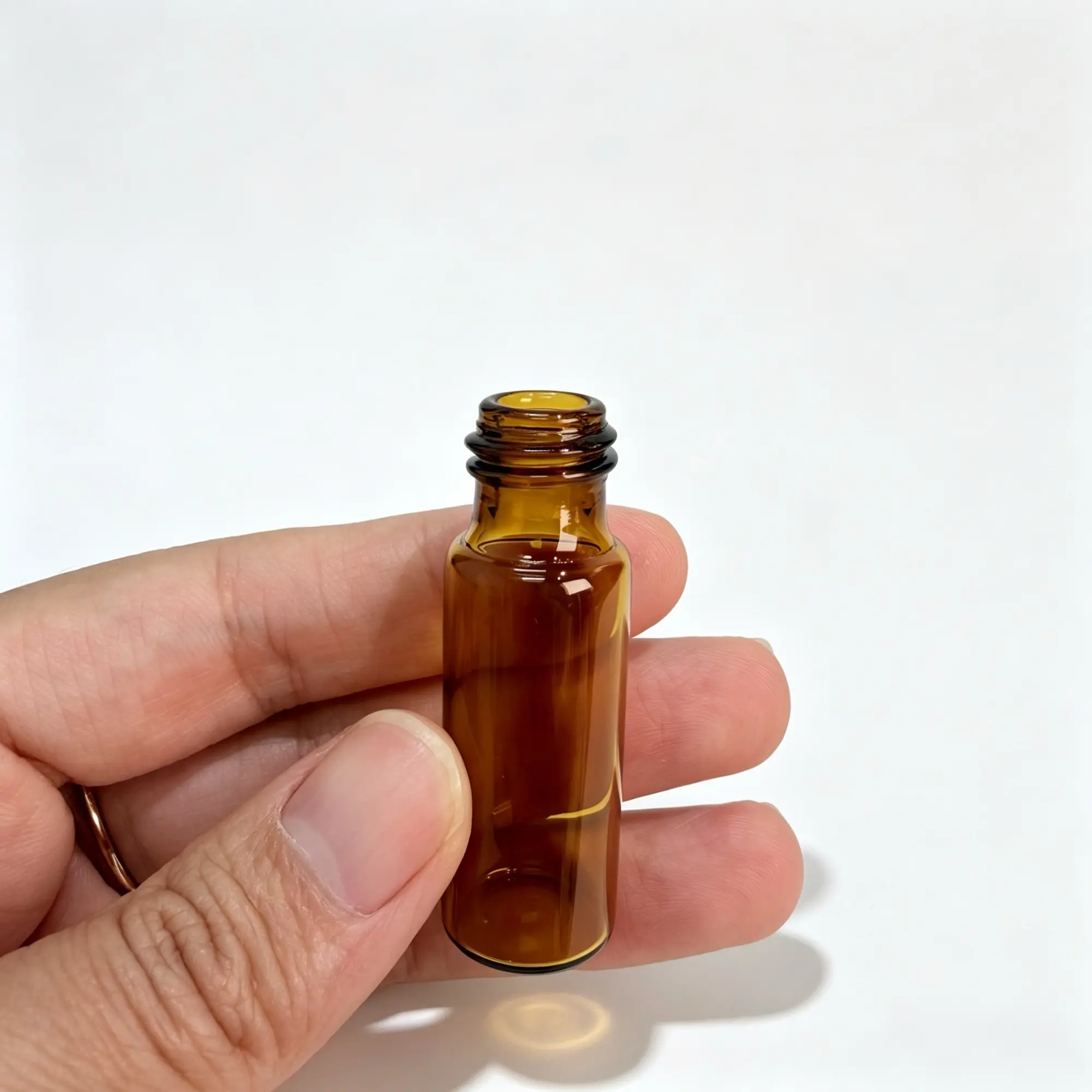 5ml Amber Roll On Bottle Handheld Bare Bottle View 5ml amber roll on bottle held in hand without the outer cap showing the compact bare bottle profile