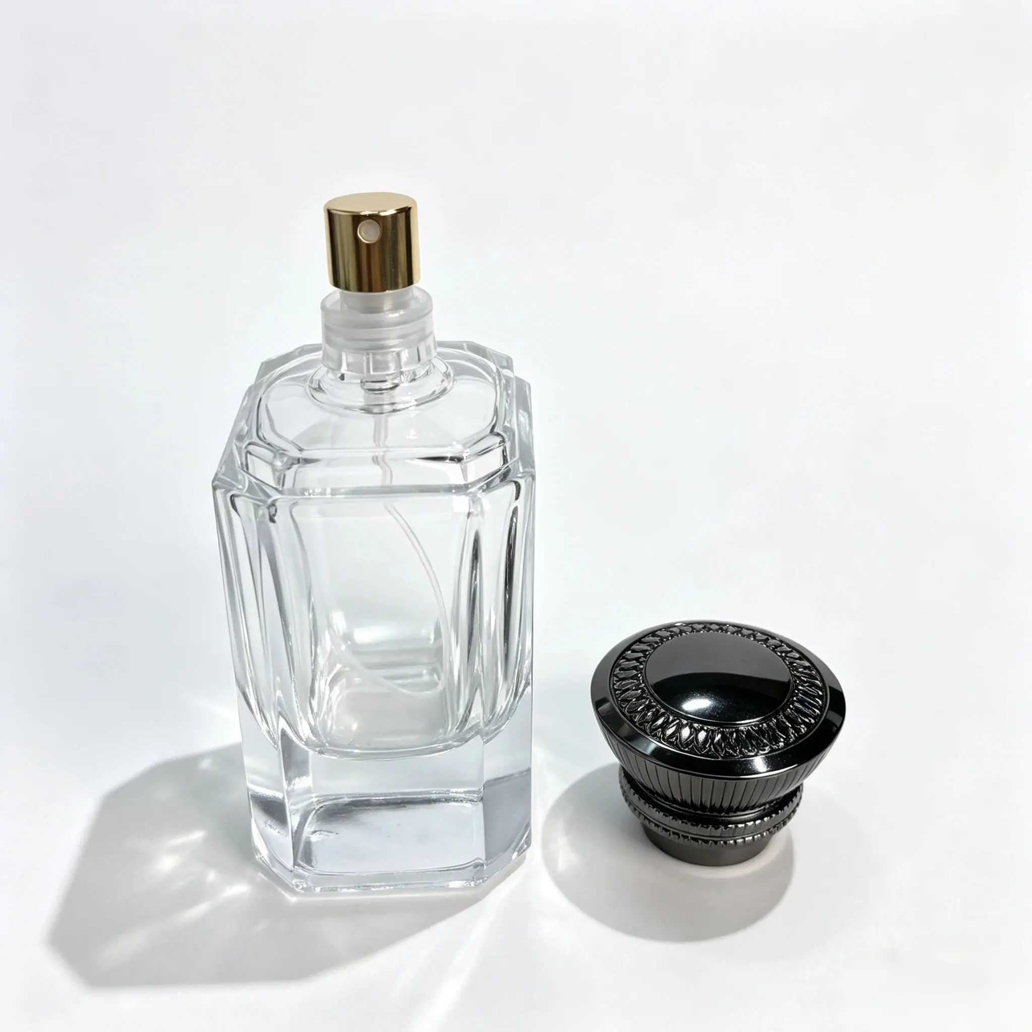 60ml Faceted Glass Perfume Bottle with Separate Black Cap 60ml faceted heavy base glass perfume bottle shown bare with the vintage style black decorative cap displayed separately beside it