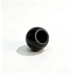 Black round ABS perfume cap shown lying at an inverted side angle with the side profile and lower opening visible