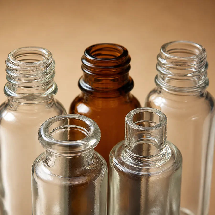 Close-up cosmetic glass bottle neck openings threads beads and sealing surfaces