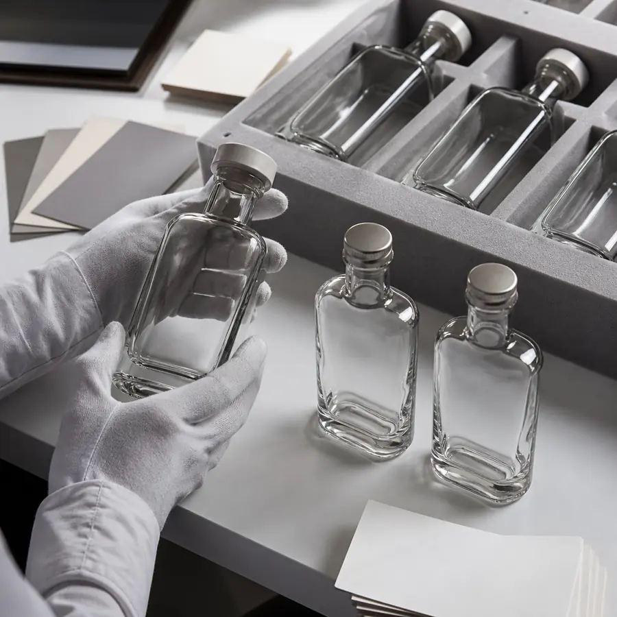 Custom glass bottle prototypes being compared during physical sample approval