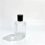 Rear view of the uncapped 100ml chamfered perfume bottle showing the vertical ribbed pattern across the bottle body and its exposed neck.