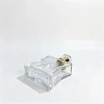 Side-lying base view of the 100ml curved waist perfume bottle showing the bottle bottom and contoured body profile.