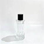 Vue de face du flacon de parfum à colonne cannelée 100ml montrant son corps à nervures verticales, son pulvérisateur de parfum et son bouchon ajusté.