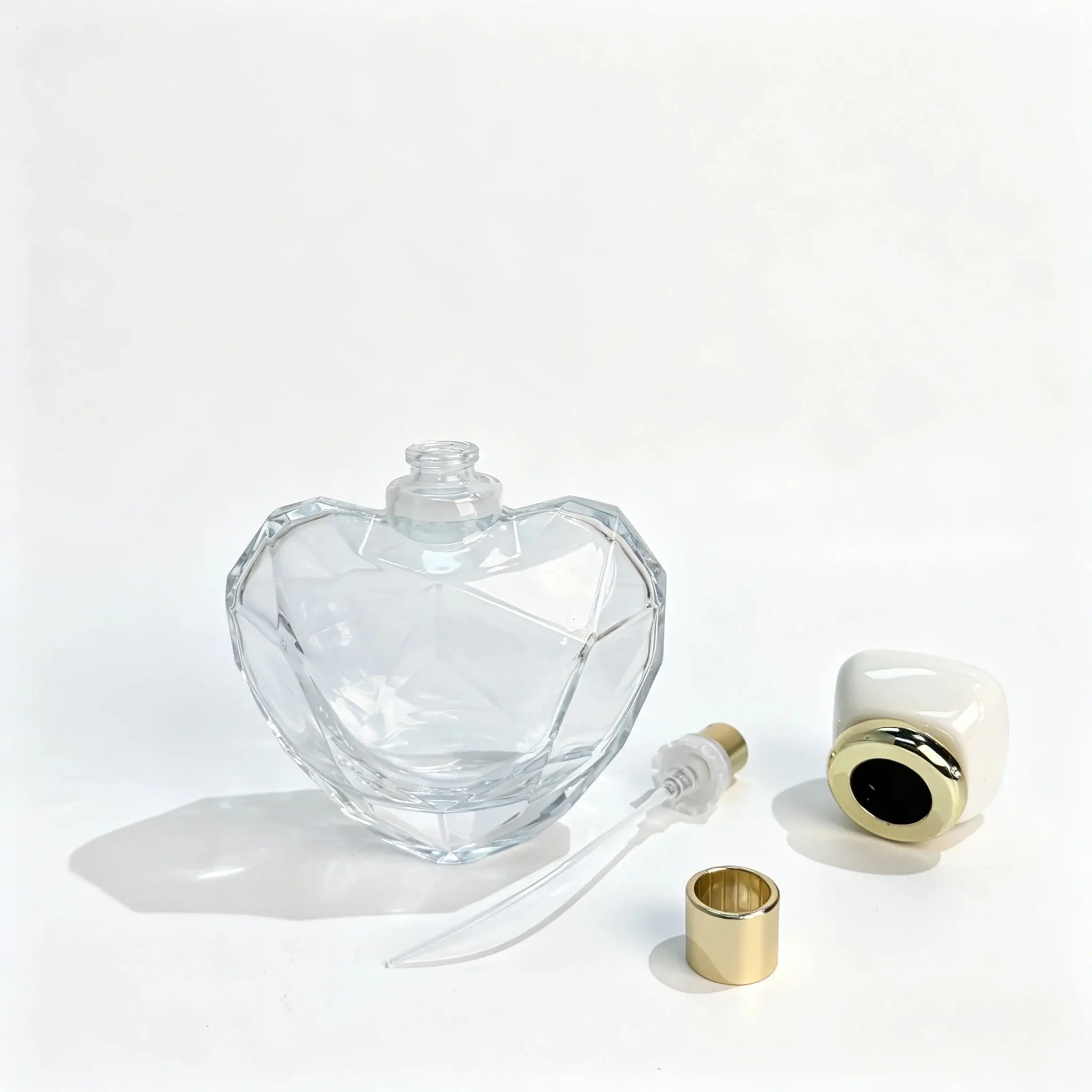 100ml Heart Perfume Bottle – Sprayer, Dip Tube and Cap Components 100ml heart-shaped perfume bottle displayed with its separate spray pump, dip tube, and cap components for fragrance packaging assembly evaluation.