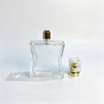 100ml hourglass perfume bottle with its cap removed and positioned beside the contoured bottle body, showing the exposed sprayer.