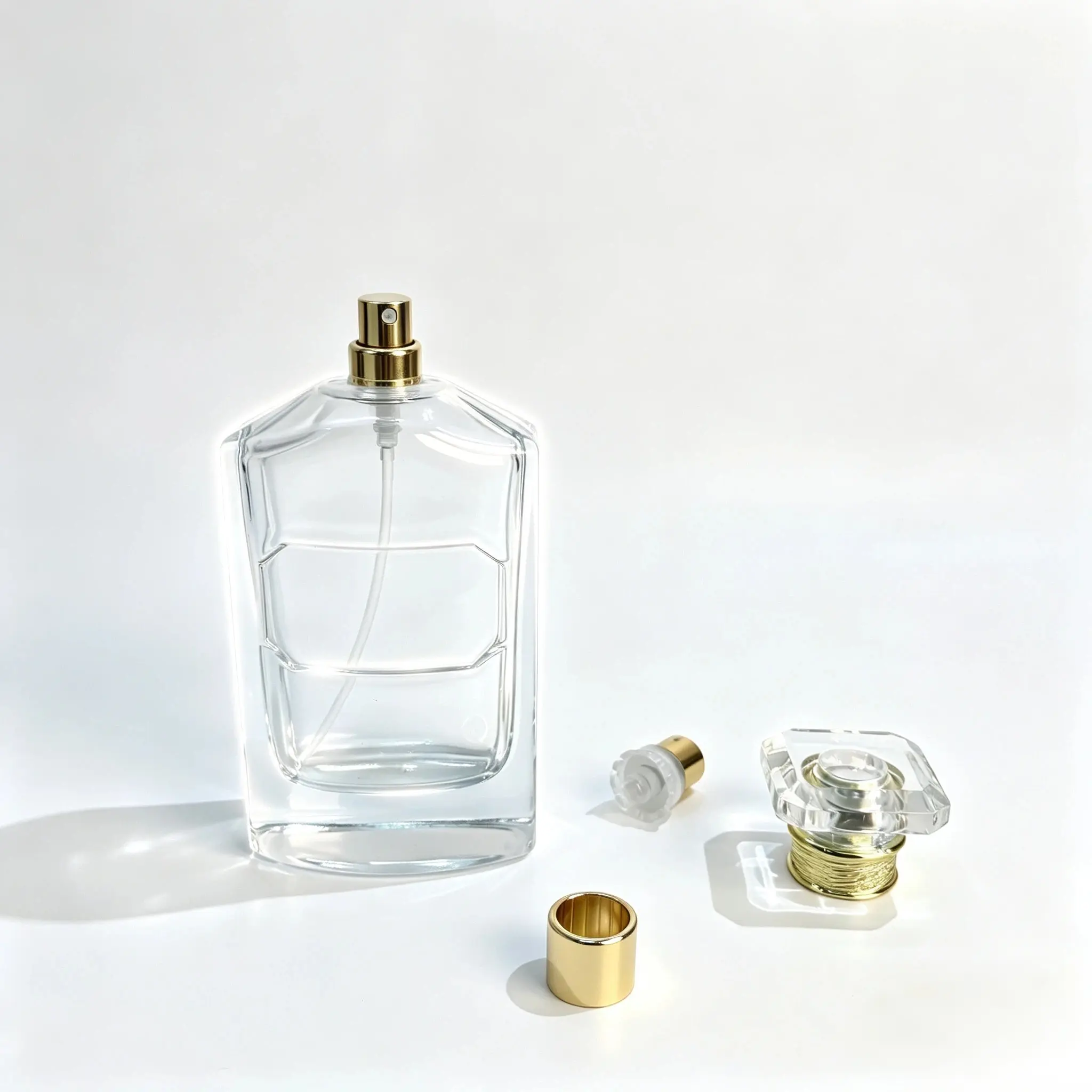 분리된 프래그런스 스프레이어, 딥 튜브, 장식 캡 부품과 함께 전시된 다면 100ml 퍼퓸 병.