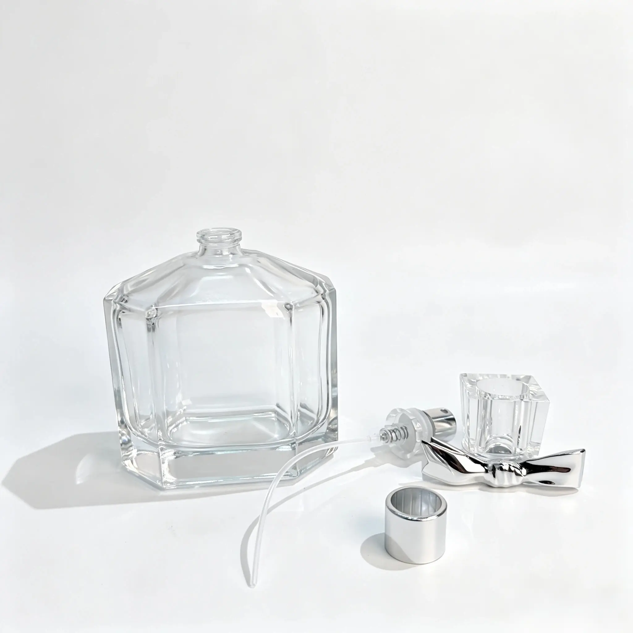 100ml Octagonal Perfume Bottle – Sprayer, Dip Tube and Cap Components 100ml octagonal perfume bottle displayed with its separate spray pump, dip tube, and outer cap for fragrance packaging component evaluation.