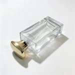 Rectangular glass perfume bottle positioned horizontally to show the cap and its relationship to the tall bottle body and thick base.