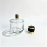 100ml short round perfume bottle with its decorative cap placed beside the bottle, showing the uncapped cylindrical profile and separate cap design.