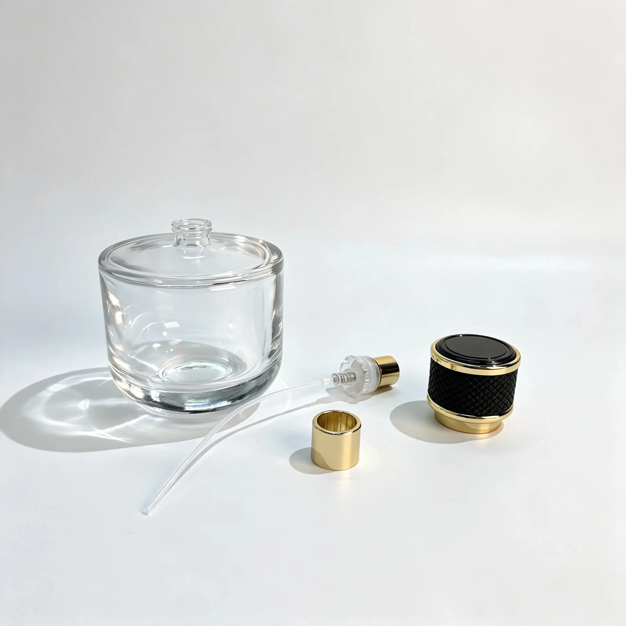 100ml kısa yuvarlak parfüm şişesi; bileşen eşleştirmesi için ayrı parfüm spreyeri, daldırma borusu ve dekoratif kapağıyla birlikte sergilenmektedir.