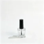 10ml rechteckige Nagellackflasche aus Glas von vorn gezeigt mit klarem Glaskörper und schwarzer Pinselkappe
