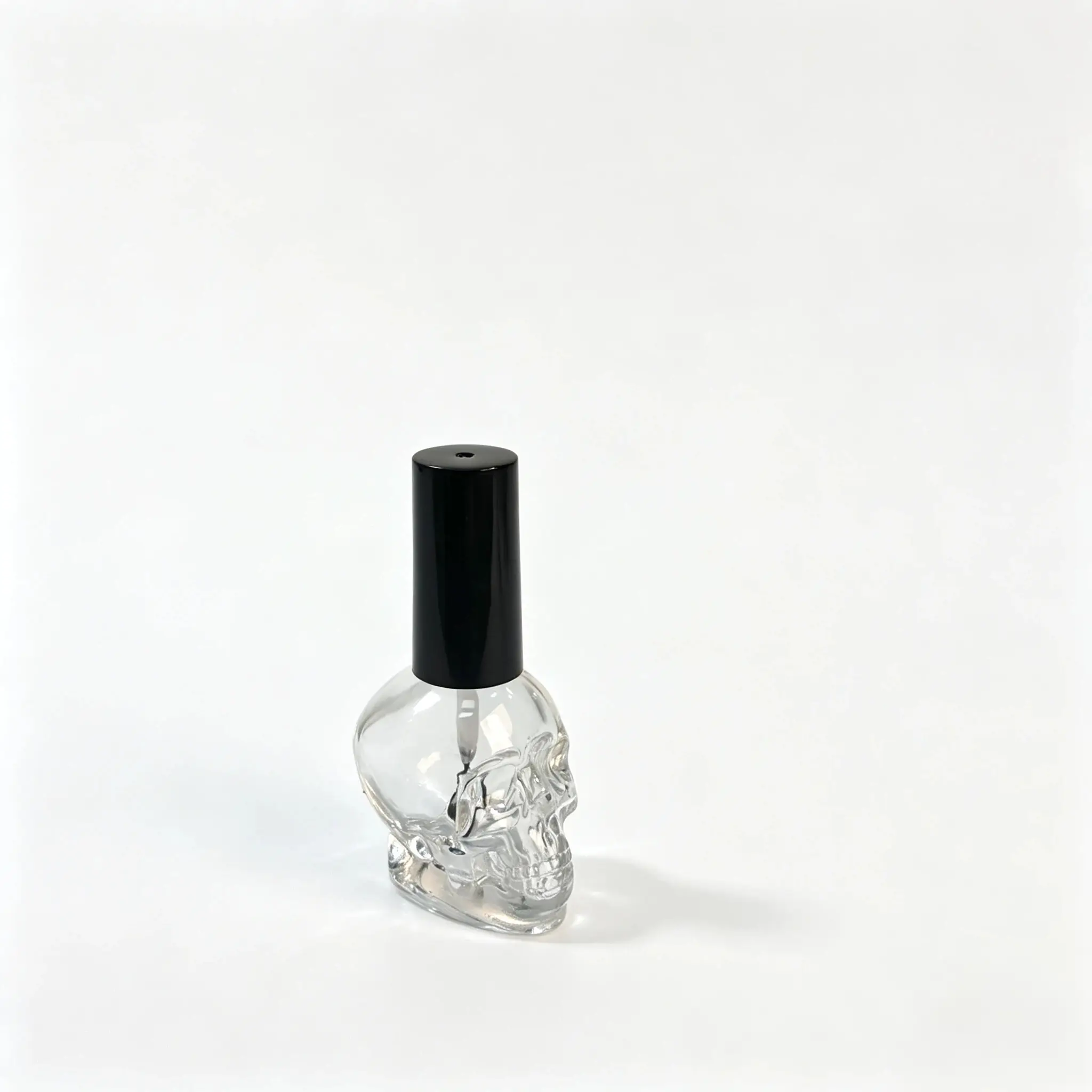 15ml Sticlă de ojă din sticlă în formă de craniu – Profil lateral Profil lateral al sticlei de ojă din sticlă în formă de craniu 15ml, care arată conturul sculptat al corpului și forma generală.