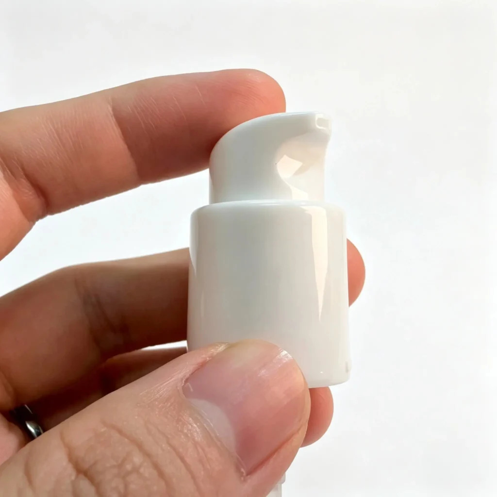 18/410 white PP lotion pump shown from the front with the dispensing actuator and pump body visible