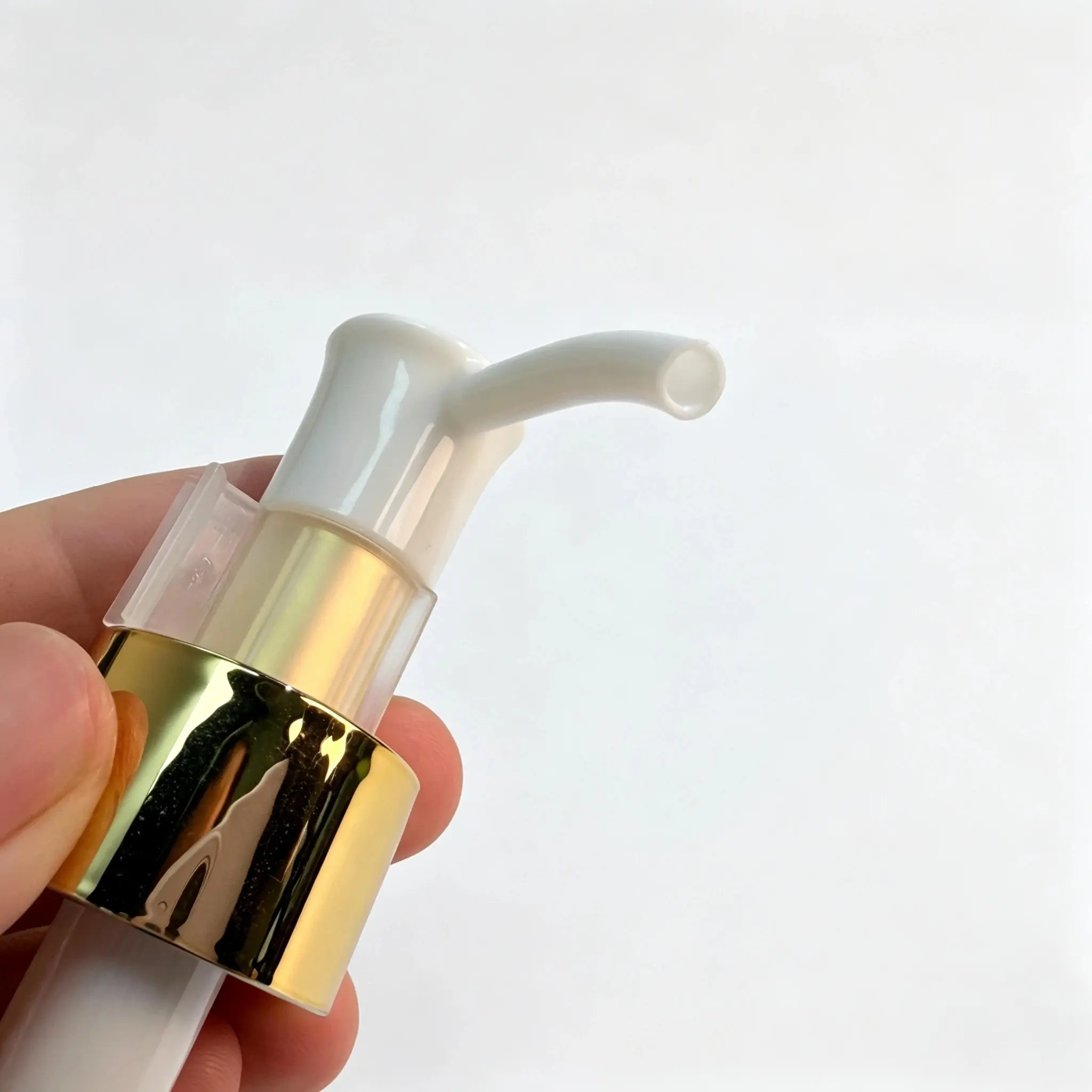 Close-up view of the gold 24/410 lotion pump showing the actuator and dispensing nozzle