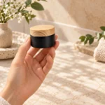 30g black glass face cream jar with a bamboo lid presented in a skincare application setting for cosmetic cream packaging.