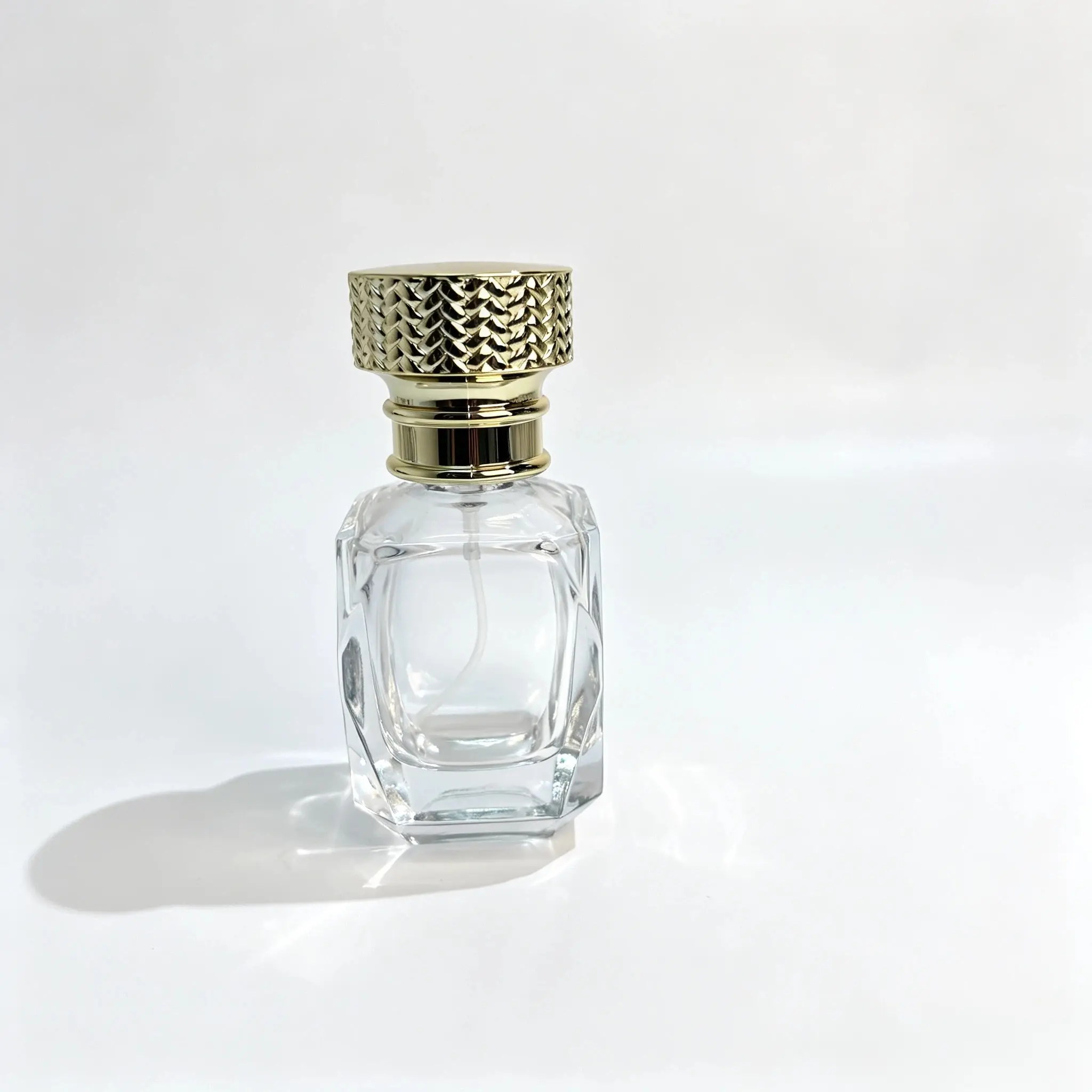 30ml Diamond Cut Glass Perfume Bottle with Woven Gold Cap – Front View Front view of the 30ml diamond cut glass perfume bottle with its geometric body and decorative woven-texture gold cap.