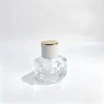 منظر أمامي لزجاجة عطر زجاجية سداسية من 30ml بجسم سميك متعدد الأوجه وغطاء أسطواني أبيض مزوّد بقمة بلون ذهبي.
