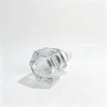 Side-lying 30ml hexagonal glass perfume bottle showing its thick glass base and angular body profile from a bottom-facing perspective.