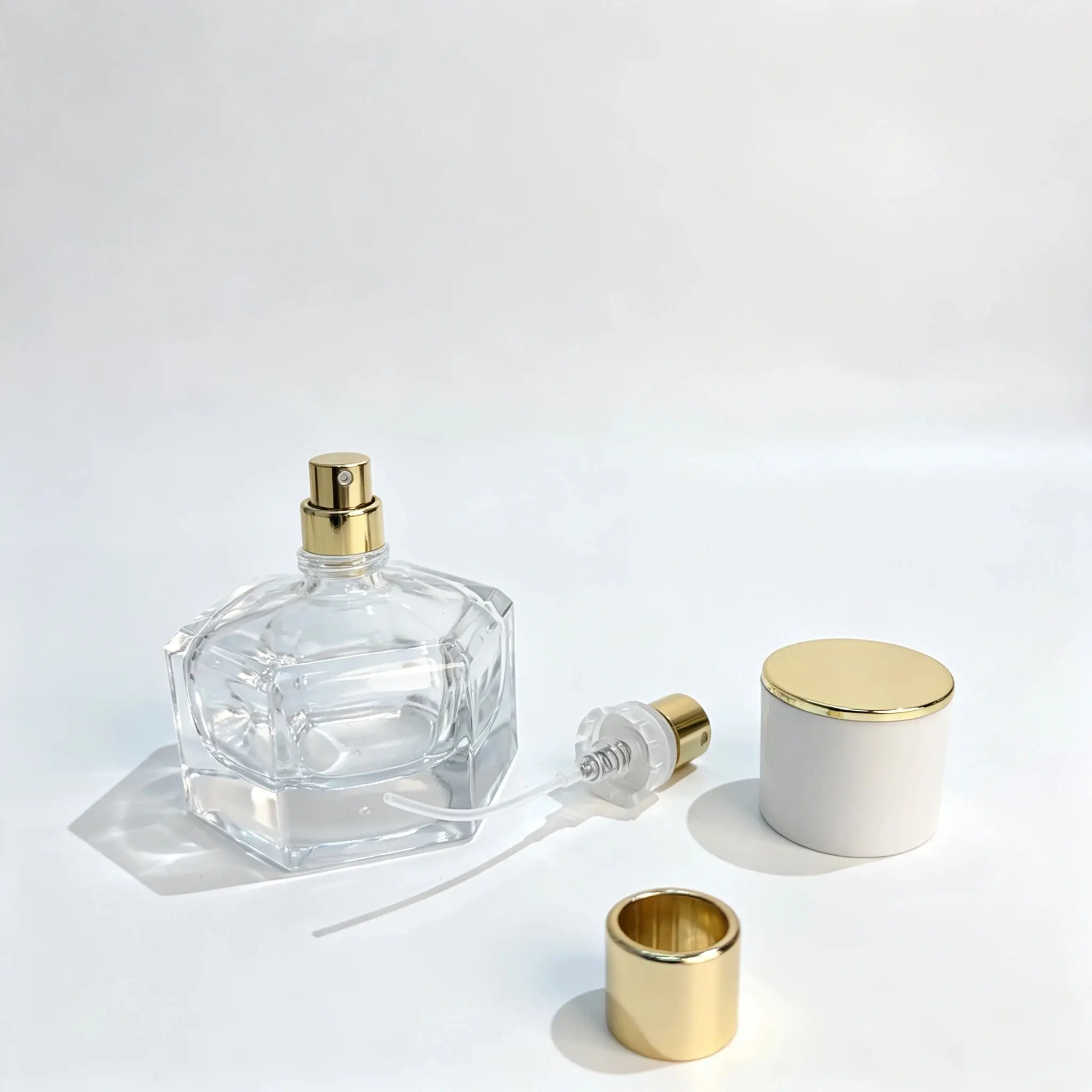 30ml زجاجة عطر سداسية – مكوّنات الرشّاش وأنبوب الغمس والغطاء زجاجة زجاجية منفصلة، ومضخة رشّ للعطر، وأنبوب غطاس، وغطاء أسطواني أبيض بقمة ذهبية اللون معروضة كمكوّنات لـ 30ml تغليف عطر سداسي.
