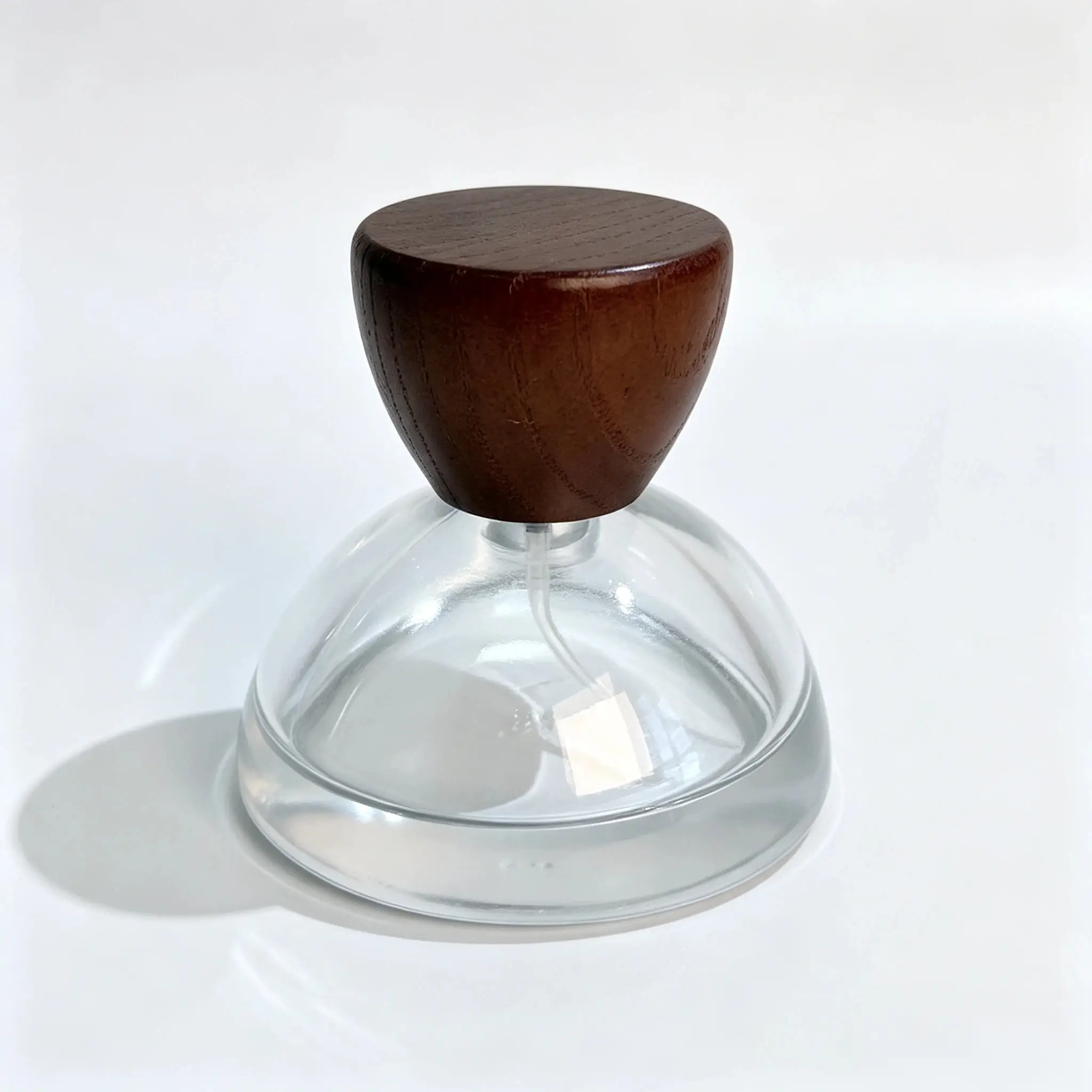 30ml Bottiglia per profumo con tappo in legno emisferico - Vista frontale Vista frontale della bottiglia per profumo 30ml con tappo in legno emisferico applicato sul suo corpo rotondo e basso.
