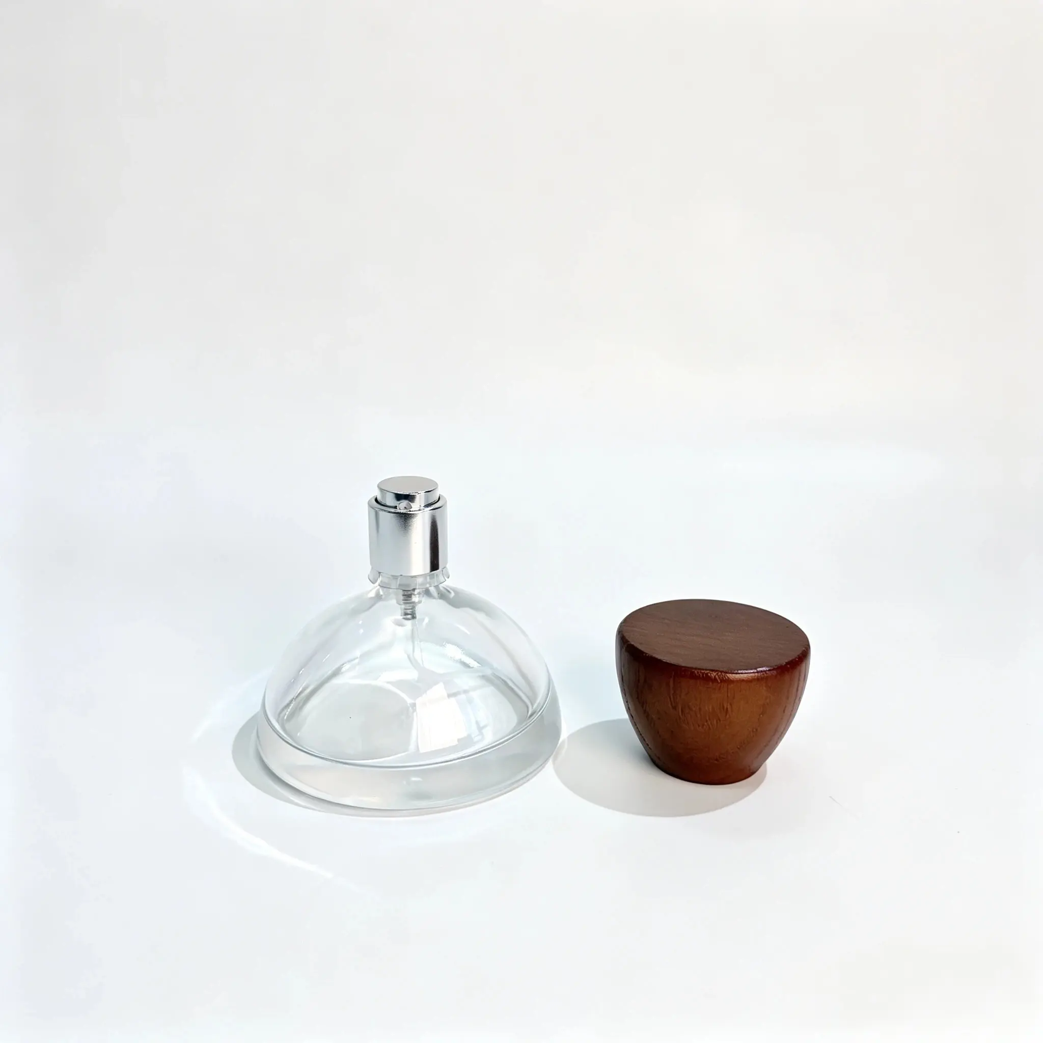 30ml Bottiglia per profumo con tappo in legno - Vista con tappo rimosso Bottiglia per profumo rotonda 30ml mostrata con il tappo in legno emisferico rimosso e posizionato accanto alla bottiglia.
