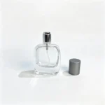 Rounded rectangular 30ml perfume bottle displayed with its gray straight cap removed and placed beside the bottle, showing the uncapped bottle profile.
