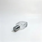 Side-lying view of the 30ml rounded rectangular perfume bottle with its gray straight cap, showing the assembled bottle and cap proportions.