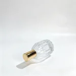 Side-lying view of the 30ml teardrop perfume bottle showing the assembled decorative cap and the vertically ribbed bottle profile.