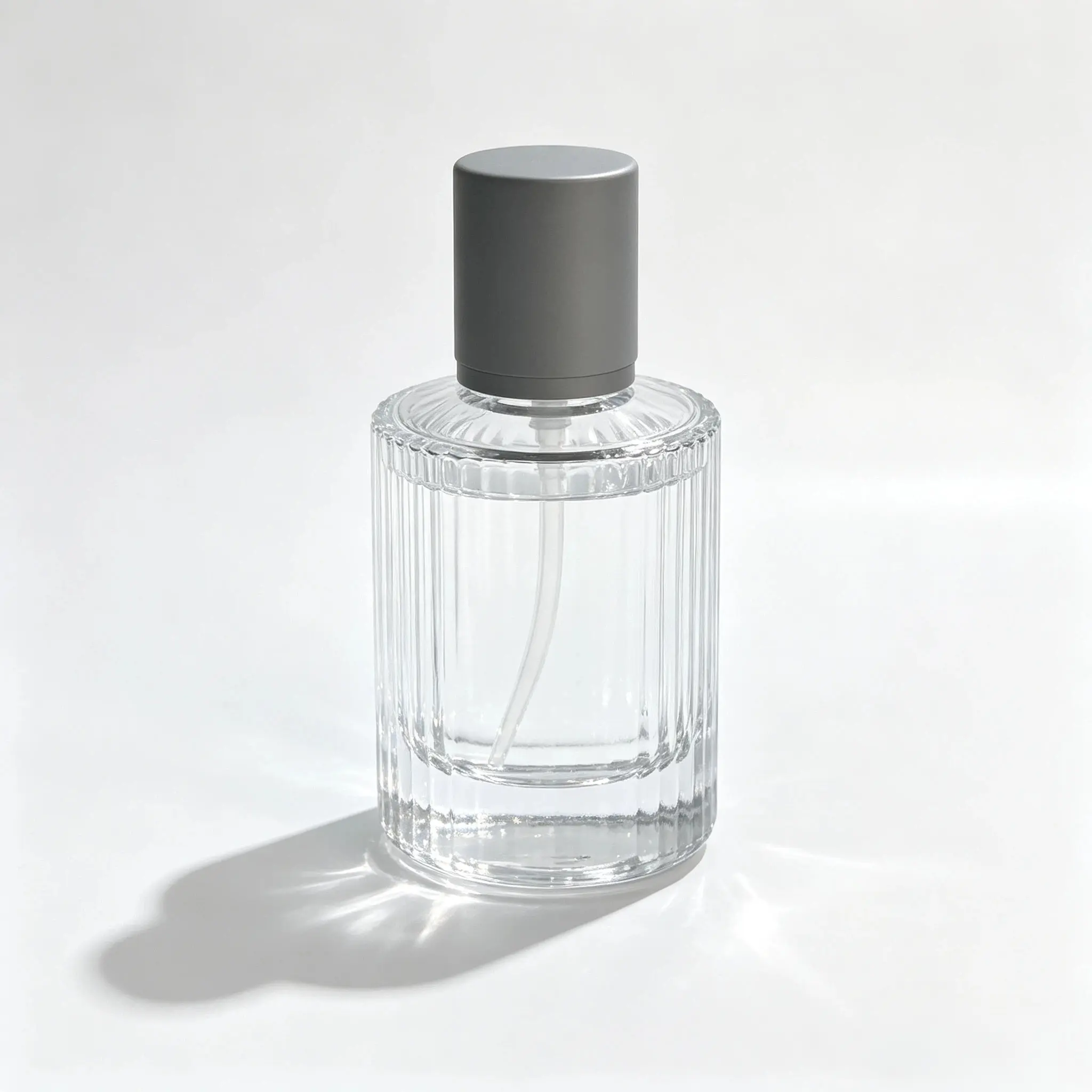 30ml dikey yivli parfüm şişesinin kompakt silindirik gövdesini, dekoratif yivli yüzeyini ve takılı kapağını gösteren ön görünüm.