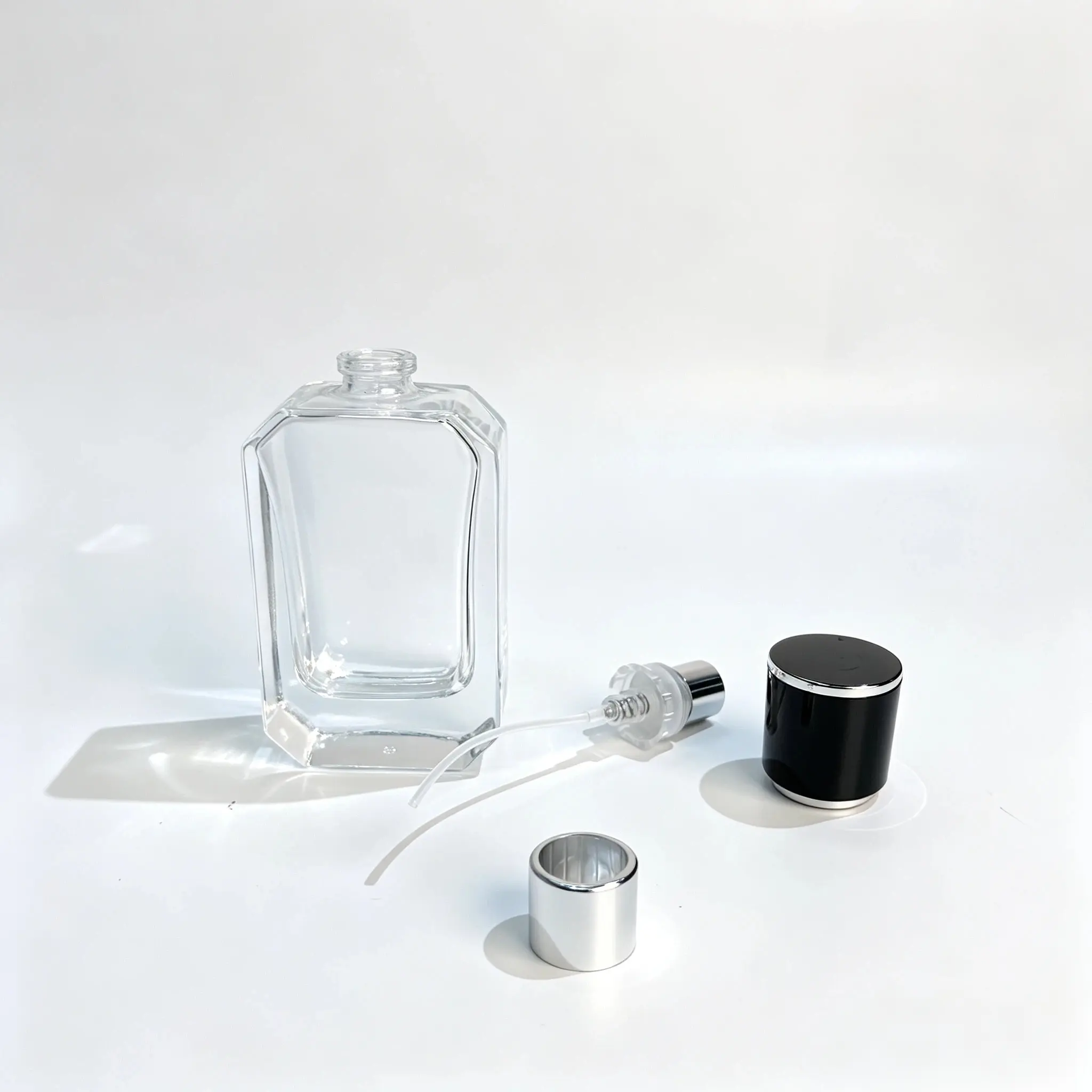 40ml Faceted Perfume Bottle – Sprayer, Dip Tube and Cap Components 40ml faceted perfume bottle displayed with its separate fragrance sprayer, dip tube, and black and silver cap components.
