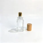 40ml square perfume bottle with its straight wooden cap removed and positioned beside the bottle, showing the uncapped bottle and separate closure.
