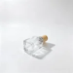 Side-lying base view of the 40ml square perfume bottle, highlighting its thick-bottom design and square bottle footprint.