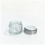 50g clear glass cream jar paired with its silver screw lid, showing the cosmetic container and closure combination