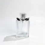 장식용 리본 디테일이 있는 50ml 플랫 직사각형 향수병의 정면도로, 조립된 병과 캡을 보여줍니다.