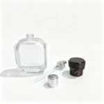 The 50ml octagonal perfume bottle displayed with its separate spray pump, dip tube, and black coil-design cap for fragrance packaging component selection.