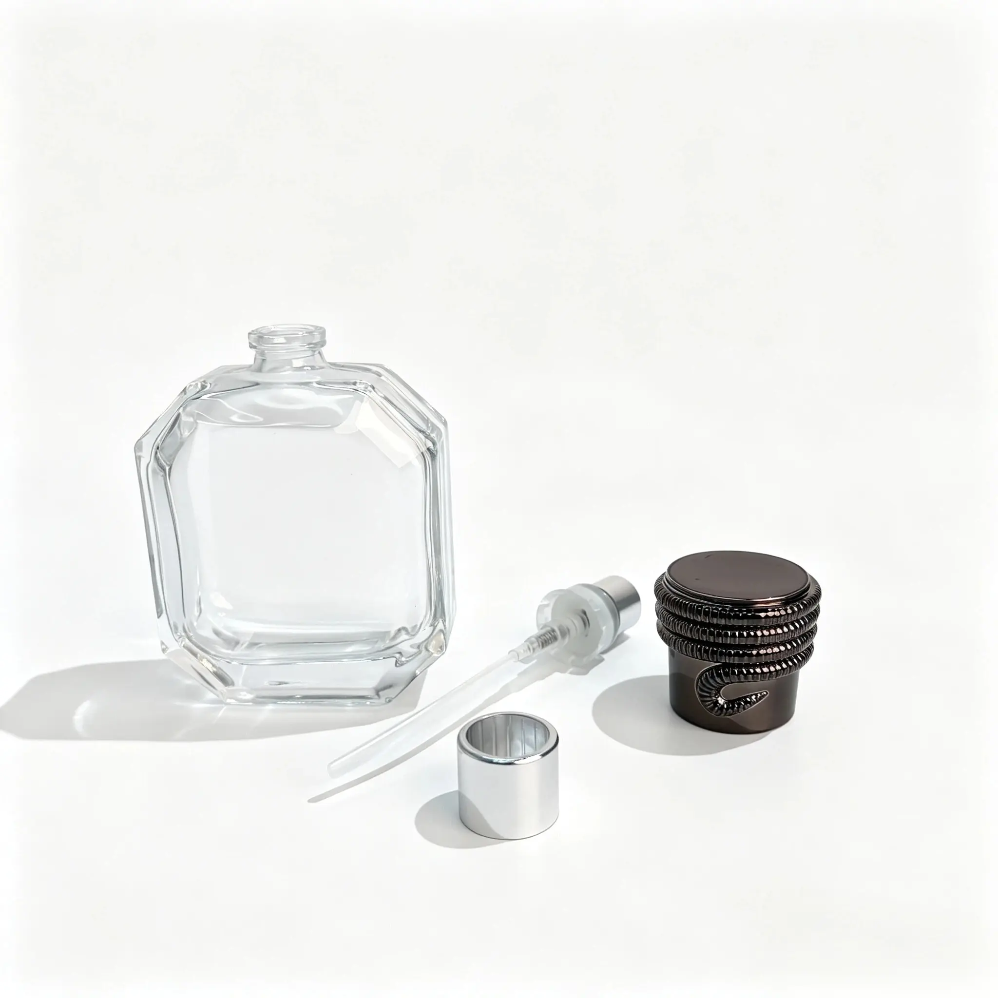 50ml Sekizgen Parfüm Şişesi – Sprey Pompası, Daldırma Borusu ve Siyah Spiral Kapak Bileşenleri Bileşen seçimi için ayrı sprey pompası, daldırma borusu ve dekoratif siyah spiral tasarımlı kapağıyla birlikte sergilenen 50ml sekizgen parfüm şişesi.