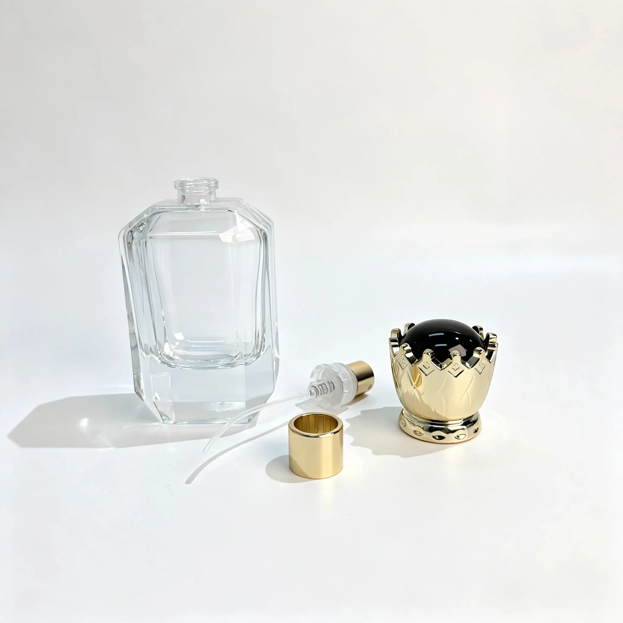 50ml Perfume Bottle – Sprayer, Dip Tube and Crown Cap Components Separate perfume spray pump, dip tube, crown-shaped cap, and 50ml bottle components arranged for packaging assembly evaluation.