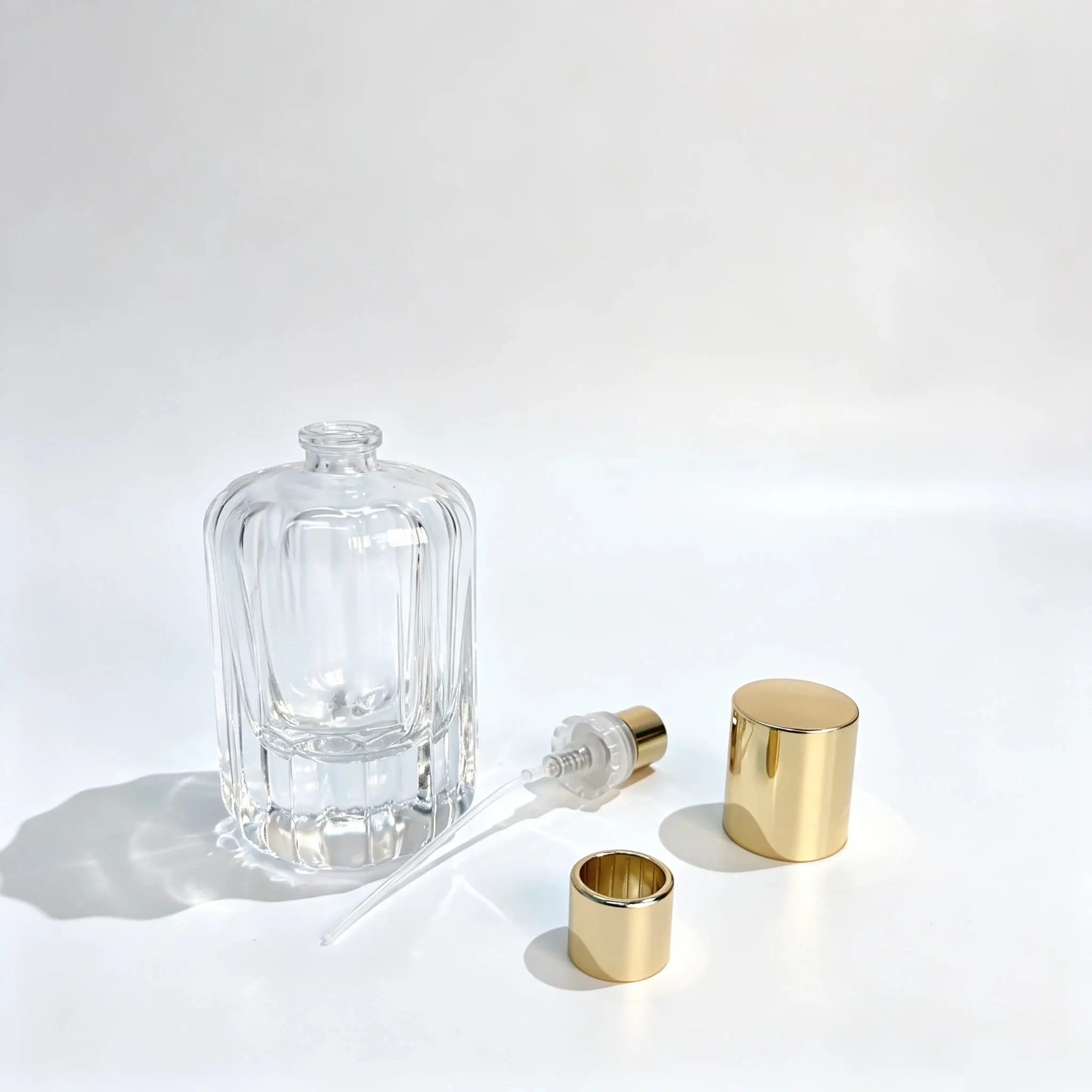 Flacon de parfum à côtes pétales 50ml présenté avec un vaporisateur de parfum, un tube plongeur et un capuchon décoratif séparés